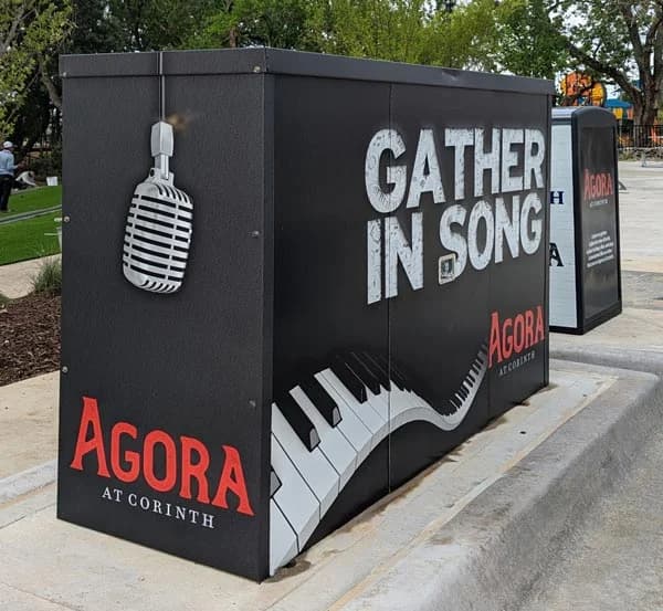 Agora at Corinth outdoor utility box wrap — Gather in Song, with vintage microphone and piano keyboard graphics by WrapMasters
