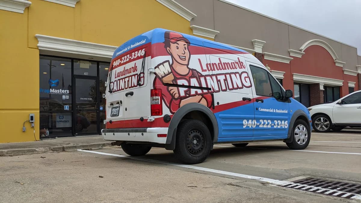 Landmark Painting van fully wrapped in red, white, and blue with a painter mascot, by WrapMasters