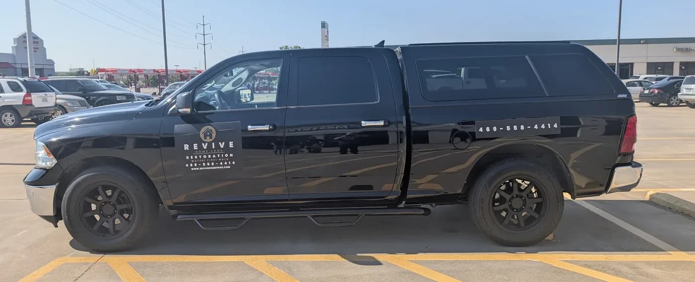 Revive Home Pros black pickup before its wrap, carrying only a small door decal and a phone number