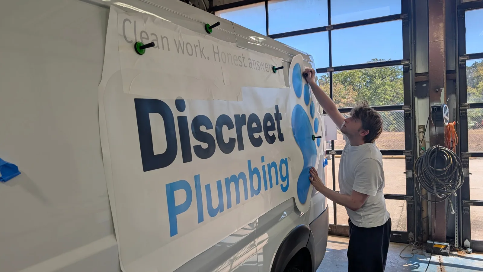 Installer positioning the printed Discreet Plumbing side panel with magnets before application