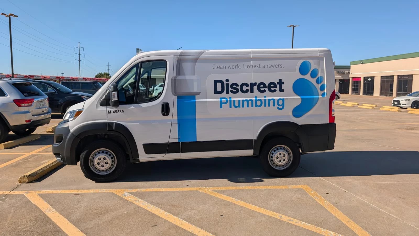 Discreet Plumbing van driver side, matte graphics on gloss factory white