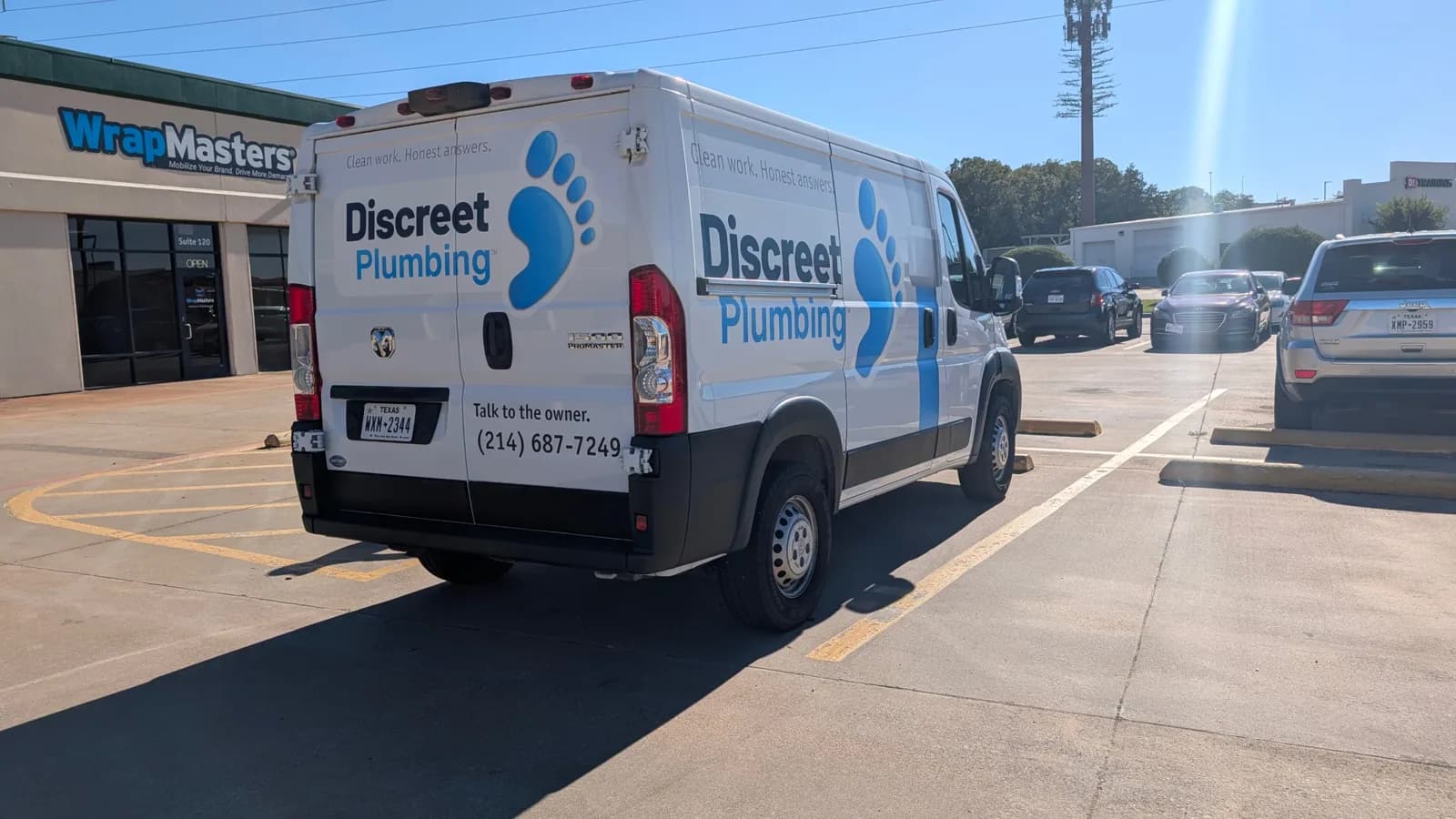 Discreet Plumbing van rear three-quarter view outside the WrapMasters shop in Denton