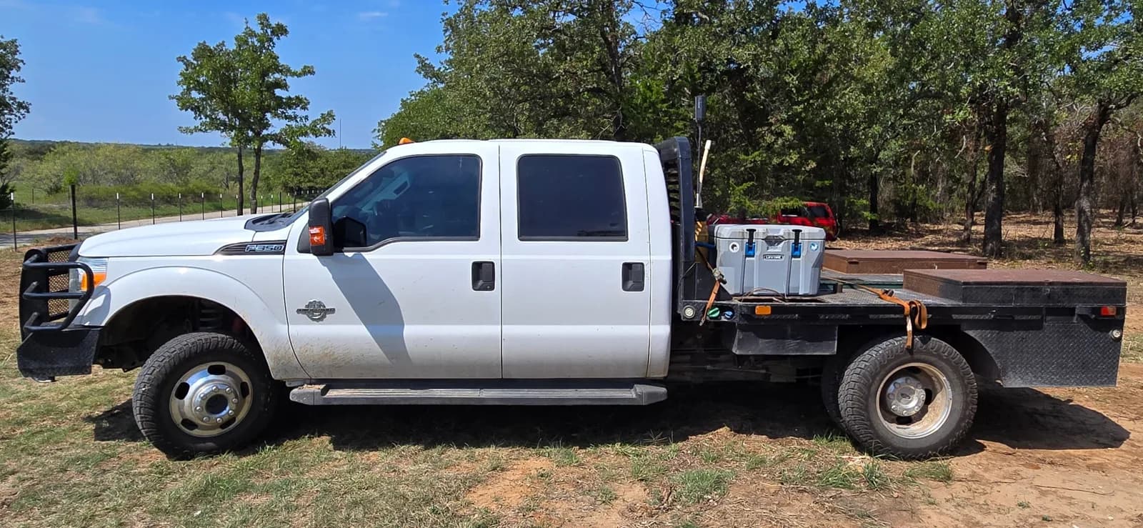 The F-350 flatbed before the wrap, driver side, at a ranch fencing job