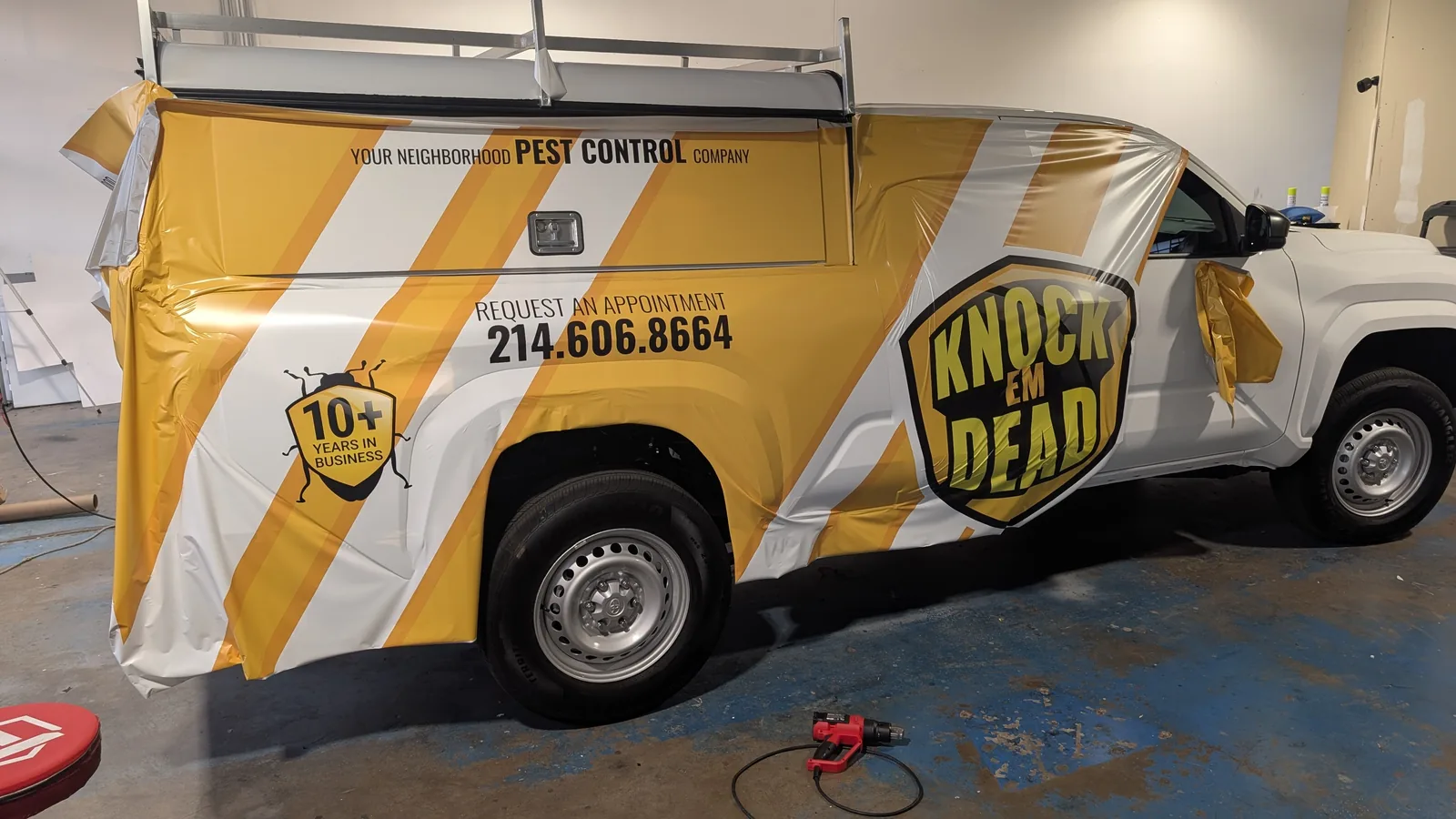 The Knock Em Dead Tacoma mid-installation in the WrapMasters shop in Denton