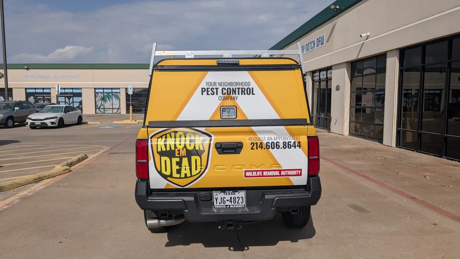 Knock Em Dead Pest Control truck wrap rear view, shield and phone number on the tailgate and shell, by WrapMasters