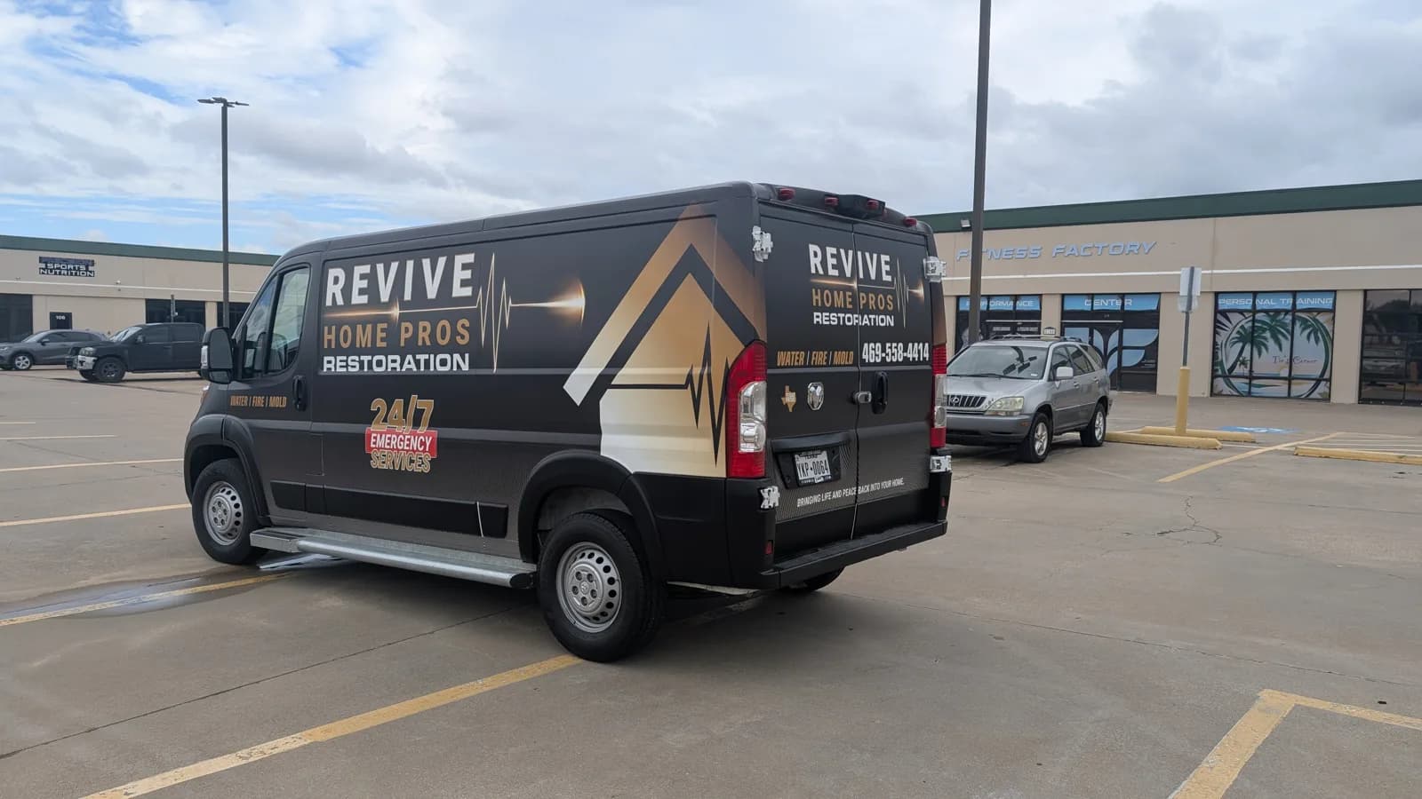 Revive Home Pros van rear three-quarter view with the name and phone number on the back doors
