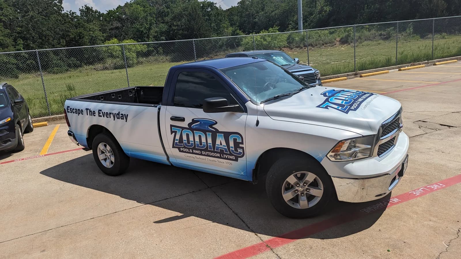 Zodiac Pools and Outdoor Living Ram pickup wrap with Escape the Everyday on the bed side
