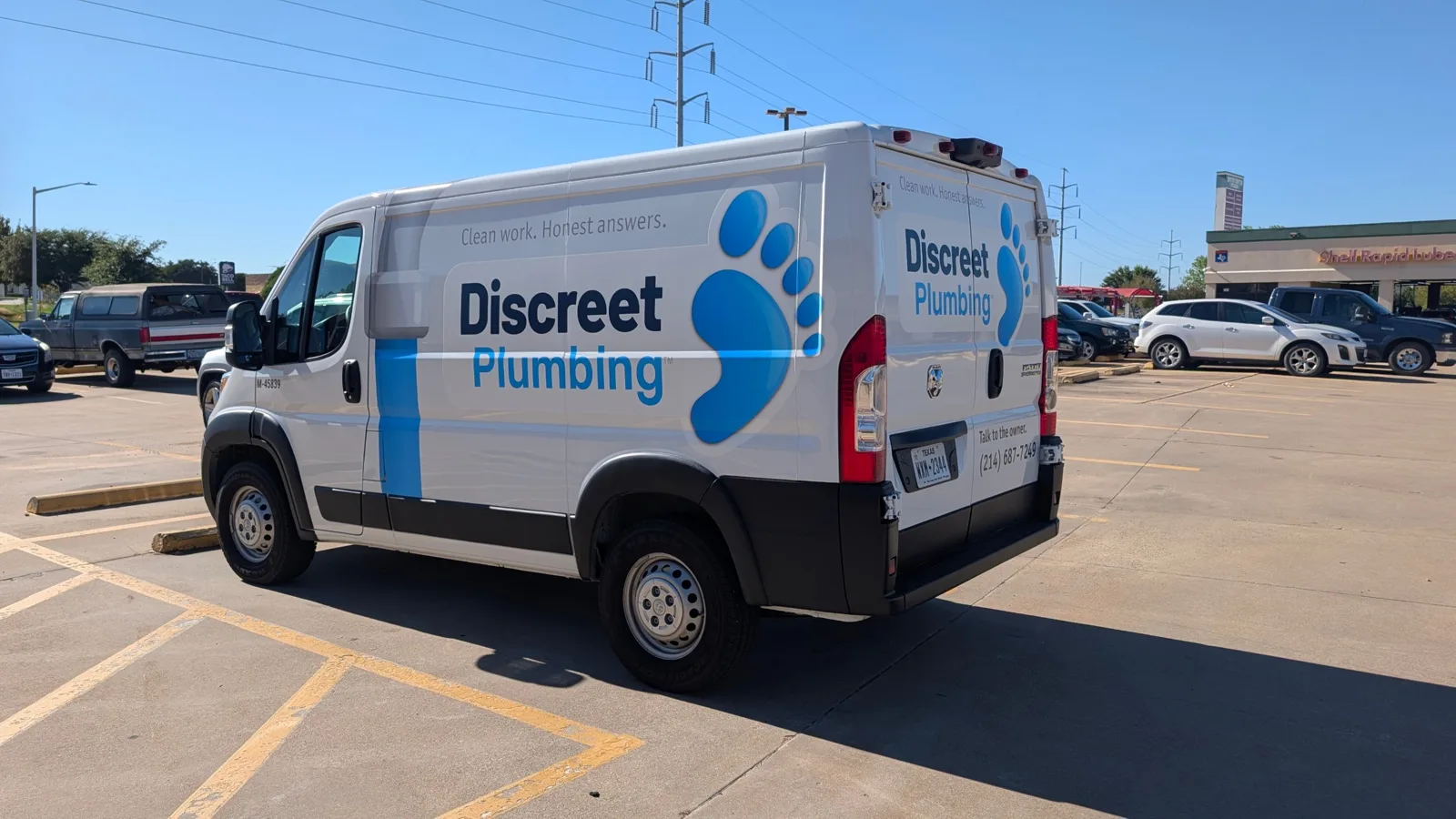 Discreet Plumbing van driver side and rear, the partial wrap reading as one layout against the gloss factory white