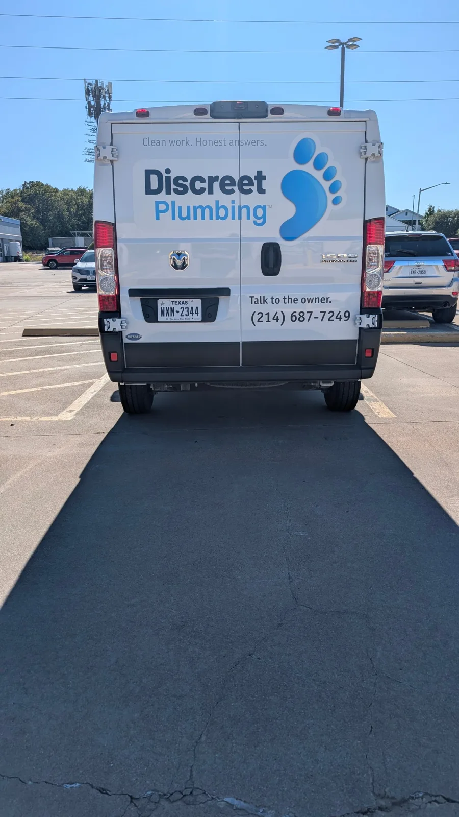 Discreet Plumbing van rear doors: the name, the footprint mark, Talk to the owner., and the phone number