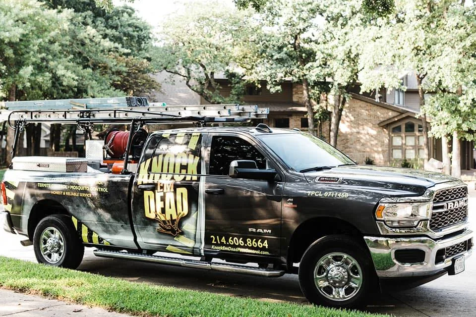 An earlier Knock Em Dead Pest Control truck wrap with the line Honest and Reliable Service, a list of treatments, and the name in distressed type across the rear window
